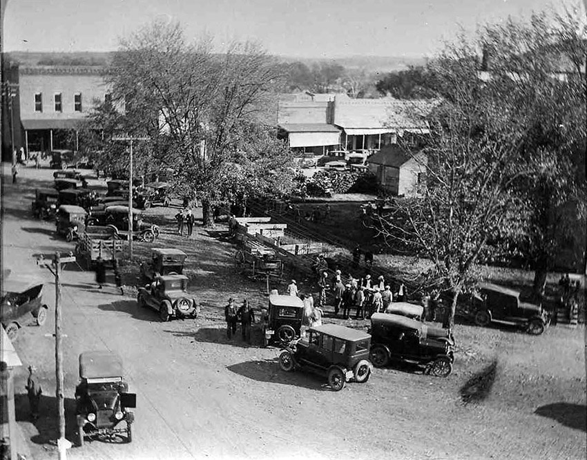 Large number of old cars on streets of downtown square