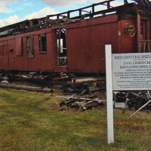 red wooden train car on display with white sign