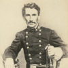 White man with mustache sitting in military uniform with sword