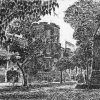 Brick building with central tower and park with trees and monument featuring charging soldier