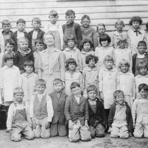 White woman with a group of white children in class photograph
