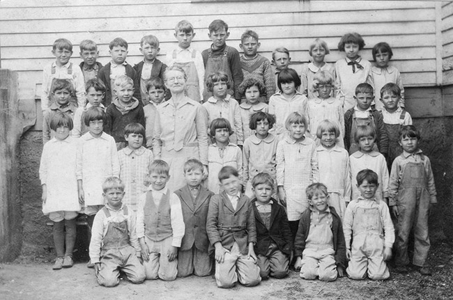 White woman with a group of white children in class photograph