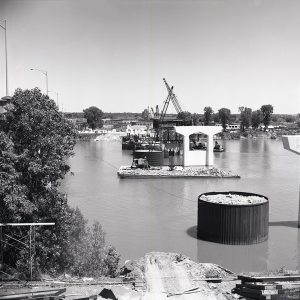 Concrete bridge supports being built in river with crane barges