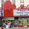 Mixed group of people standing under theater marquee advertising "The magic of Maxwell Blade"