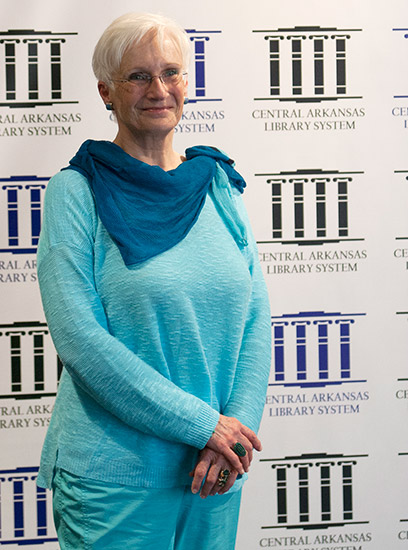 white woman with white hair wearing glasses in blue shirt and pants