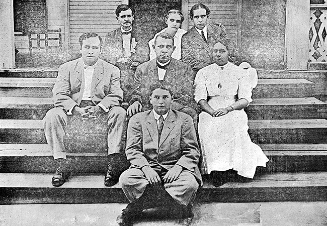 African-American men and women sitting on front porch steps