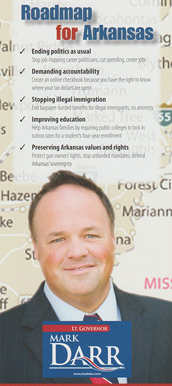 White man in suit and tie on "Roadmap for Arkansas" campaign brochure