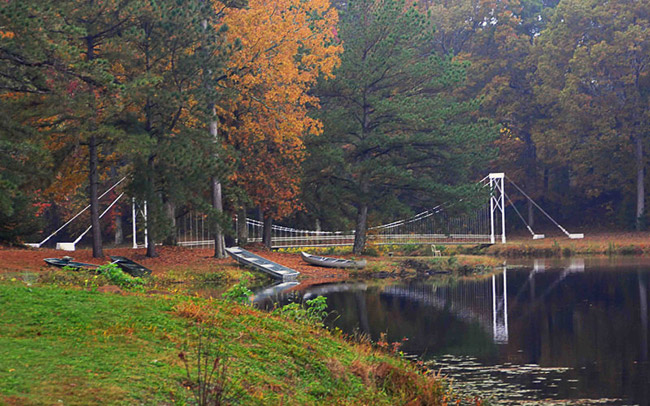 Suspension bridge over water with fall foliage