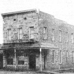 Two-story brick building and storefront on dirt road