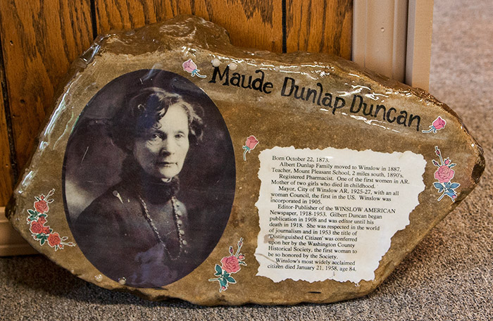 Portrait of white woman with necklace and text on rock face labeled "Maude Dunlap Duncan"