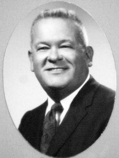 smiling light-haired white man in suit jacket and tie