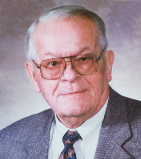 Older white man with glasses and gray hair in suit jacket and tie