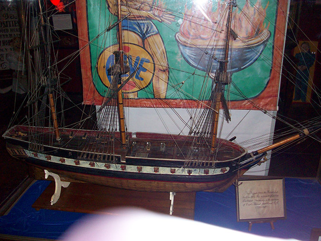 Model ship and banner in glass case