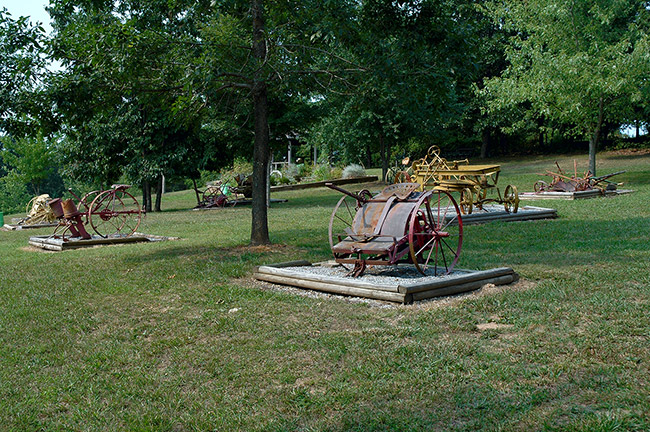 Farming machinery on display in a field with wooden platforms