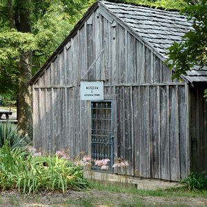 Single-story "museum and general store" building with picnic area in the background