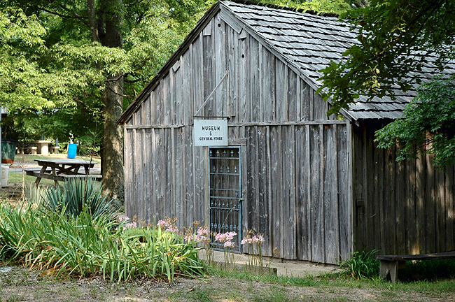 Single-story "museum and general store" building with picnic area in the background