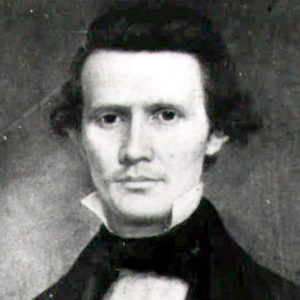 White man with curly hair in suit and white shirt