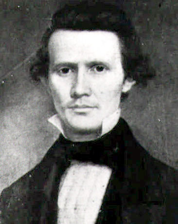 White man with curly hair in suit and white shirt