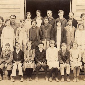 Group of white students outside school house