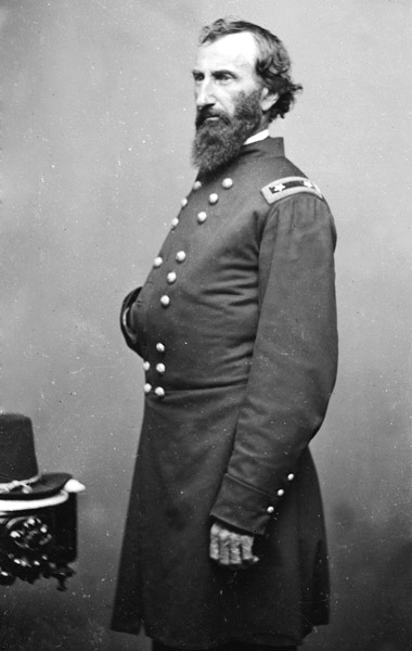 white man with beard posing with one hand inside his military jacket