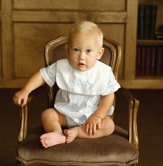 White blond baby sitting in chair