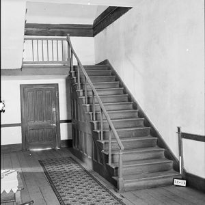 Stairs and hallway with rug and wood furniture