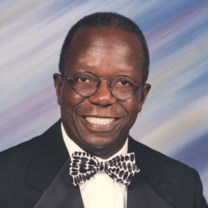 African-American man with glasses smiling in suit and bow tie