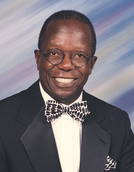 African-American man with glasses smiling in suit and bow tie