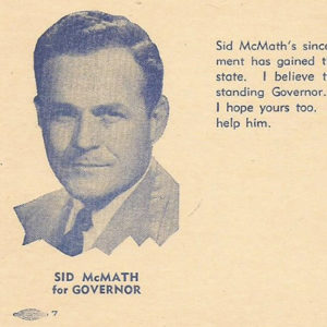 White man in suit and tie on campaign post card with blue text