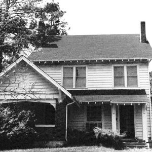 Two-story house with covered porch and brick chimney