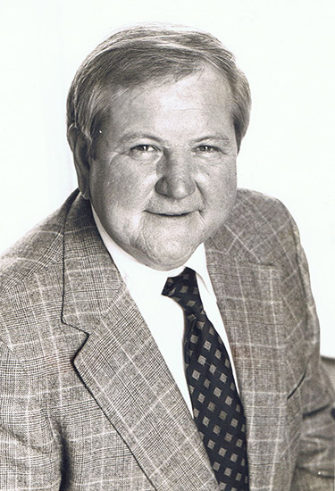 Older white man in suit jacket and tie