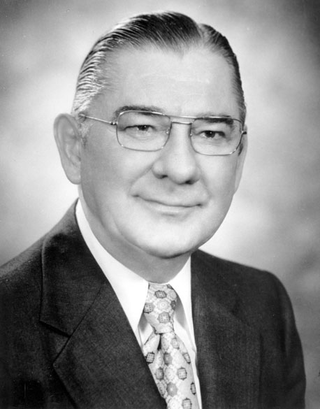White man with glasses in suit and decorative tie