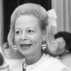 Older white woman smiling in pearl earrings and necklace