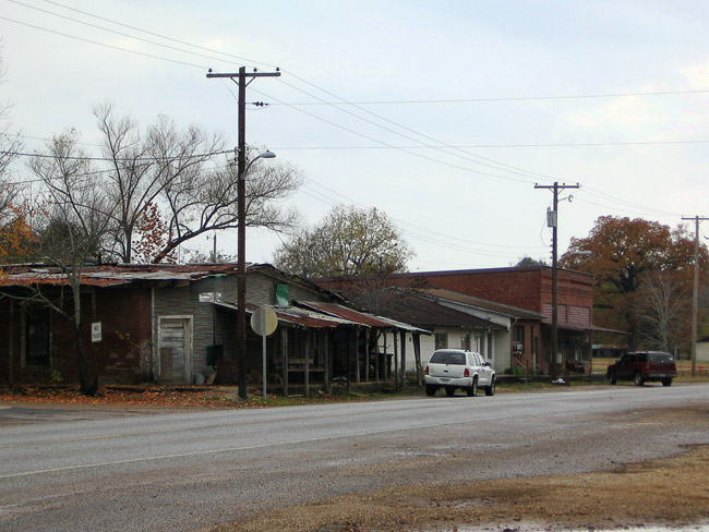 Street with run down buildings and cars and power poles with lines