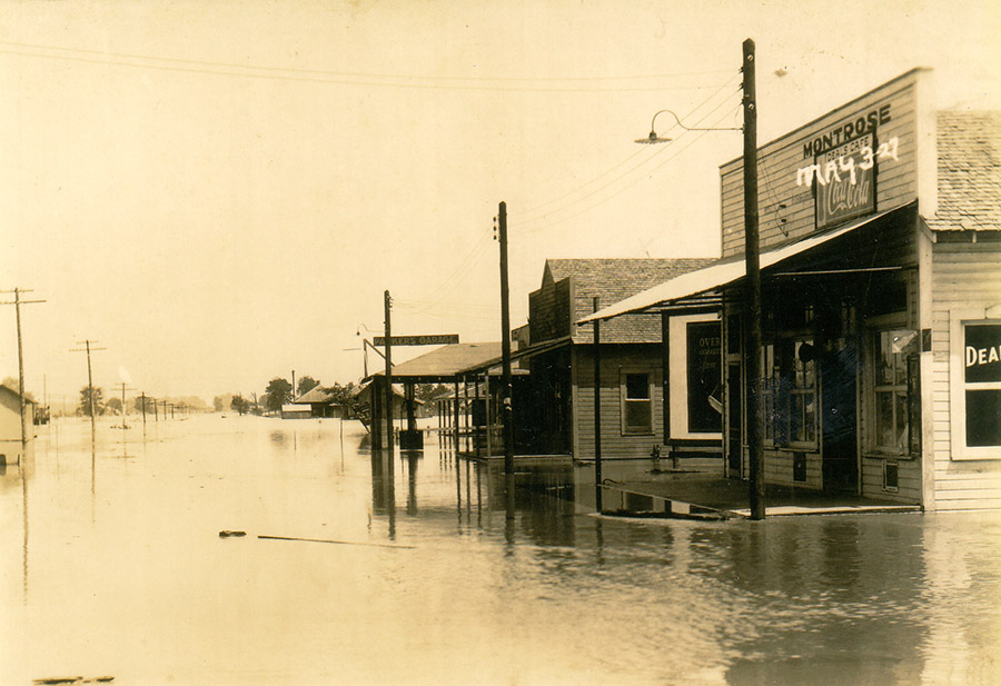 Storefronts and power lines on flooded streets