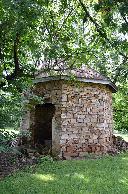 Ruins of stone brick smokehouse with roof