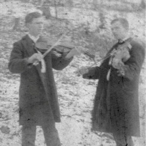 Two white men in suits playing fiddles