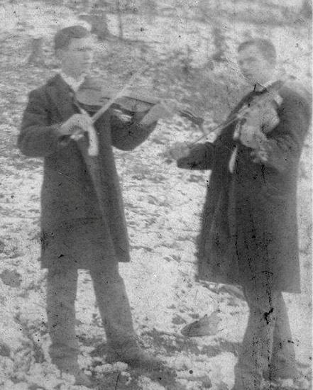 Two white men in suits playing fiddles