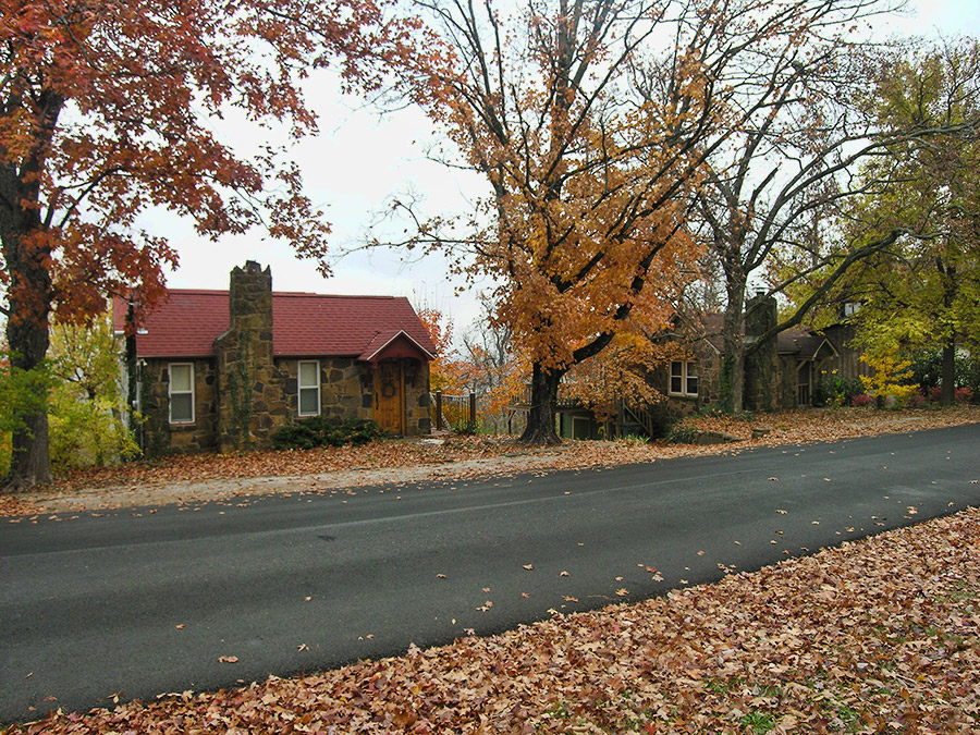 Small stone cottages on street with autumn trees on both sides