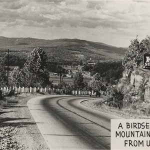 Mountain road with town and countryside in the background from "K. C. Studio" labeled "A Birds eye view of Mountainburg Arkansas from U.S. Highway 71"