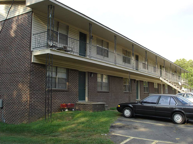 Two-story brick apartment building and parking lot with cars