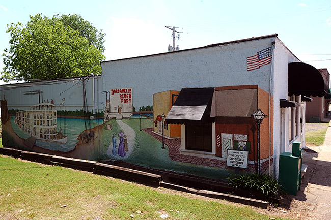 Mural with steamboat and town painted on brick building