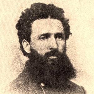 White man with bushy beard and curly hair in gray military uniform