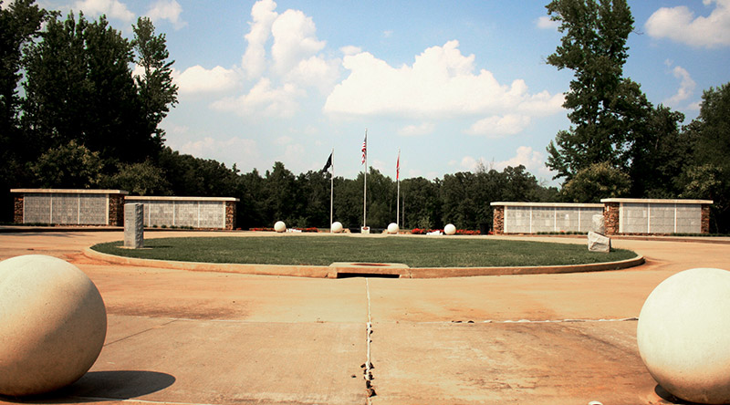 Cemetery entrance with flagpoles and monuments