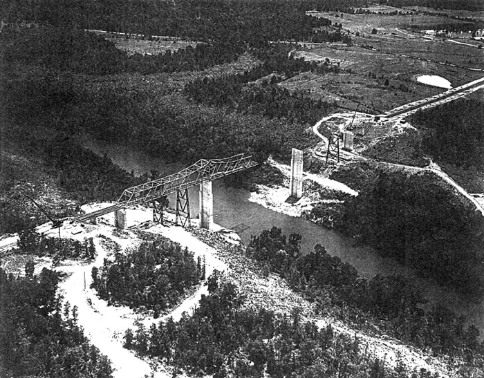 Aerial view of an unfinished steel truss bridge over a river