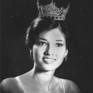 Young white woman smiling in tiara and sleeveless dress