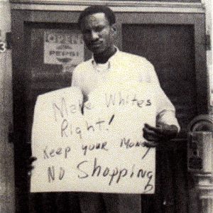African-American man with "Make Whites Right Keep your money no shopping" sign