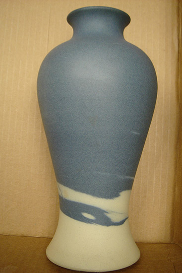 Blue vase with white swirls on its bottom section