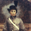 Young white man sitting in gray military uniform with hat and sword in his lap