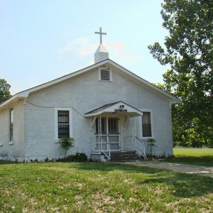 single-story church building with cross topped cupola